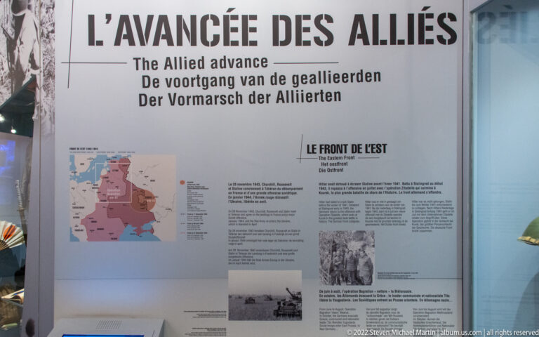 Tall museum panel titled L’Avancée des Alliés with map, text, and wartime photographs about the Allied advance.