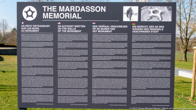 Large multilingual outdoor sign titled 'THE MARDASSON MEMORIAL' standing on the memorial grounds.