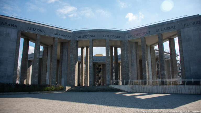 Interior view of the Mardasson Memorial's curving stone colonnade with U.S. state names carved above.