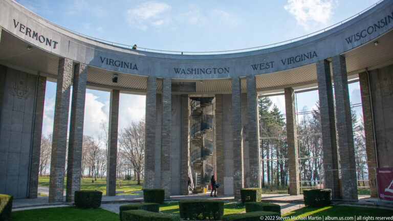 Stone columns of the Mardasson Memorial with Virginia, Washington, West Virginia, and Wisconsin carved above.