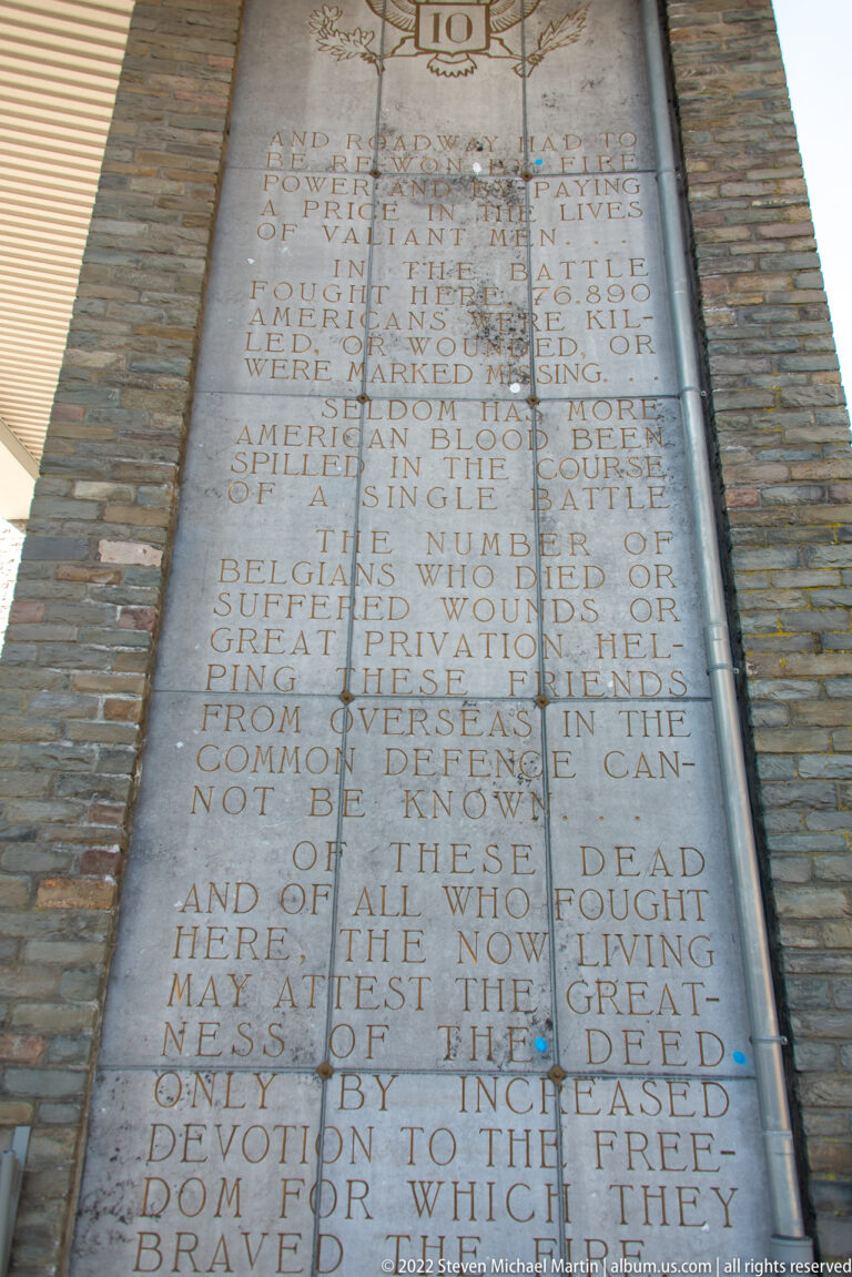 Close-up of a long English inscription carved into the stone structure of the Mardasson Memorial.