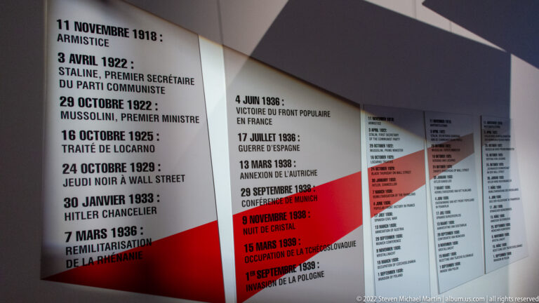 Tall museum timeline panels listing interwar European political events in black and red text.