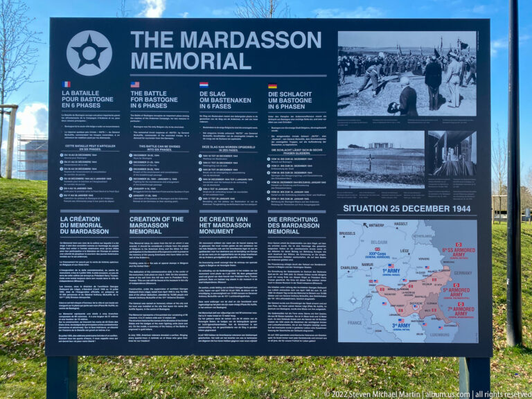Outdoor Mardasson Memorial panel with multilingual text, archival photographs, and a Battle of the Bulge map dated 25 December 1944.