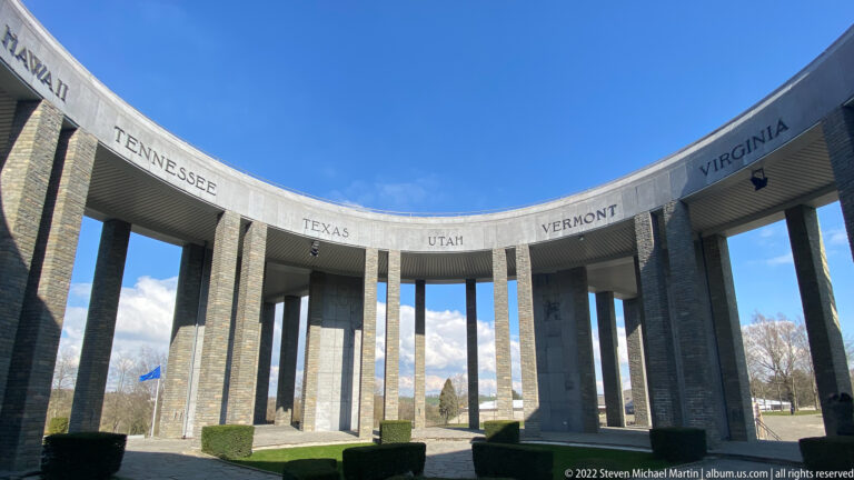Curving interior colonnade of the Mardasson Memorial with Tennessee, Texas, Utah, Vermont, and Virginia carved above.
