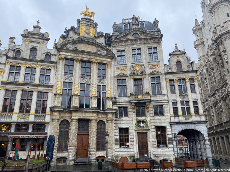 Ornate Grand-Place guildhouses with columns, sculpted pediments, gilded reliefs, tall windows, and varied rooflines.
