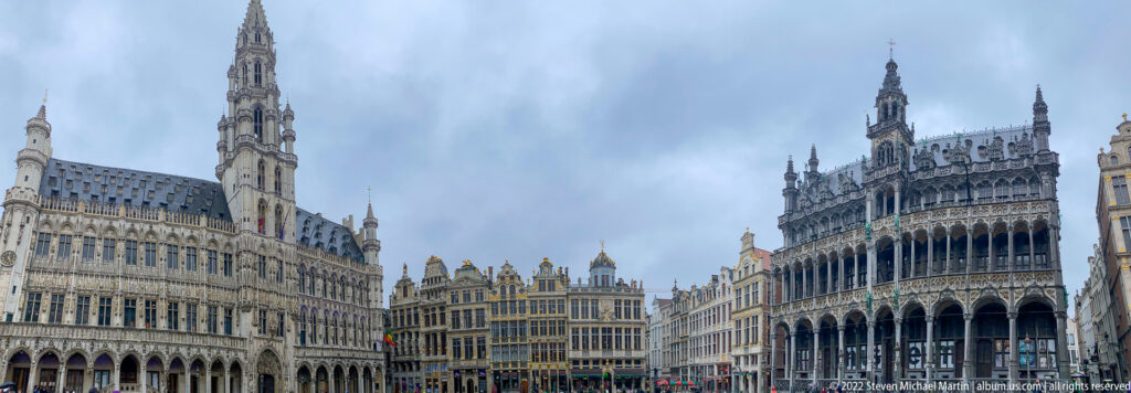 Wide Grand-Place view with Brussels Town Hall at left, Maison du Roi at right, and guildhouses between them.