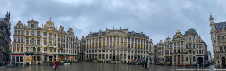 Curving row of ornate Grand-Place façades with tall windows, gilded details, sculpted rooflines, and pedestrians below.