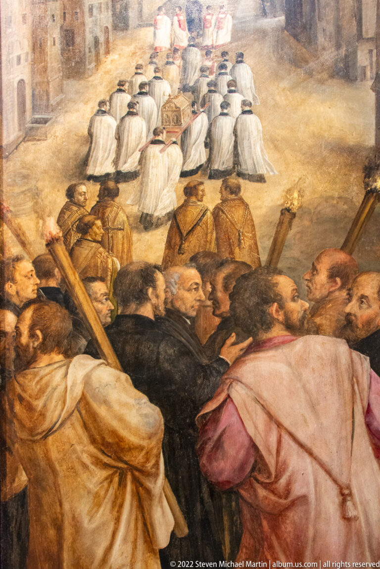 Painted crowd carrying large wooden crosses below a procession of white-robed clergy in a historical religious scene.