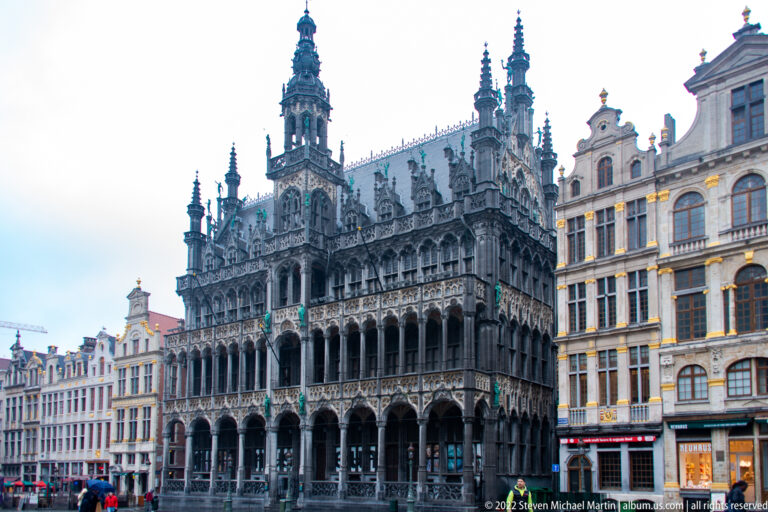 Maison du Roi on Brussels’ Grand-Place, with arcaded lower stories, ornate Gothic detailing, pinnacles, and a tall central tower.