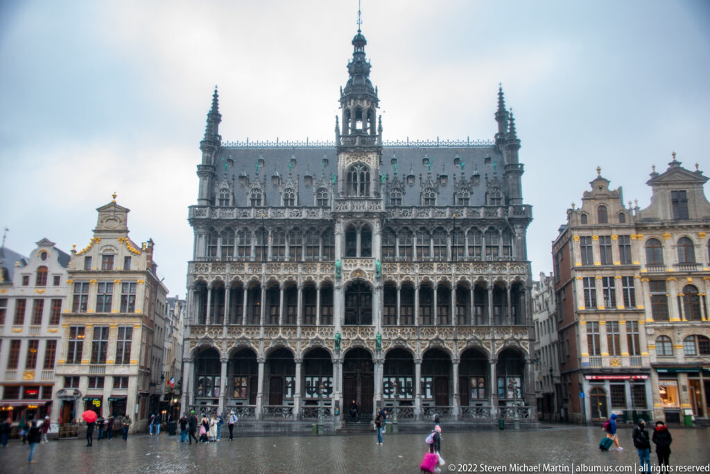 Frontal view of the Maison du Roi with arcades, pinnacles, steep roof, and central tower facing the Grand-Place.