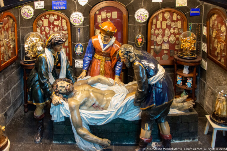 Polychrome Entombment group with the dead Christ on a white cloth surrounded by several richly dressed attendants.