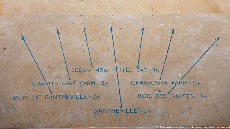 Stone orientation panel with arrows and distances to Sedan, Bantheville, Hill 343, farms, and nearby woods.