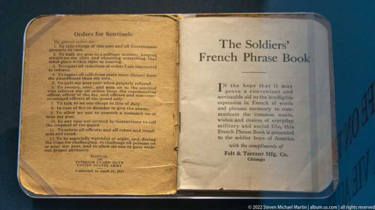 Open worn pocket book titled The Soldiers’ French Phrase Book with practical English and French phrases.