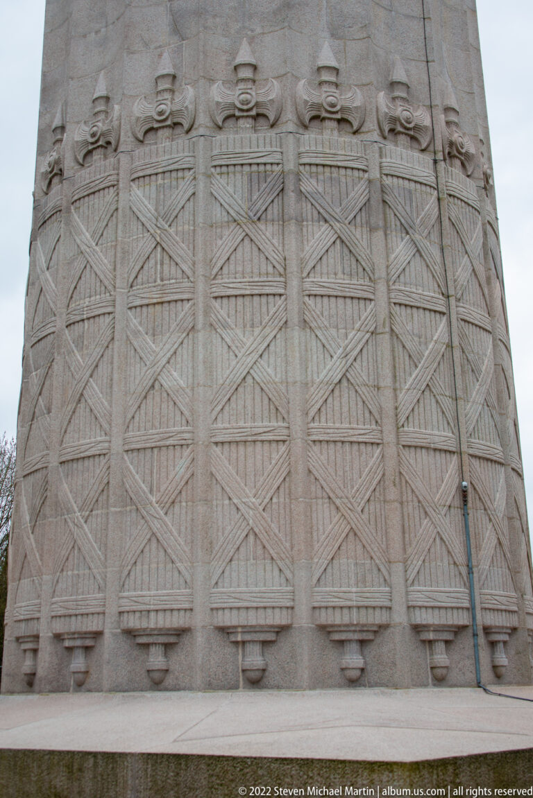 Close-up of large carved geometric panels decorating the stone base of the Montfaucon monument.