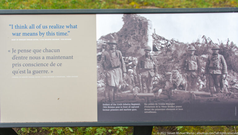 Bilingual interpretive panel with a soldier quotation and historic photograph of infantrymen standing beside ruins.