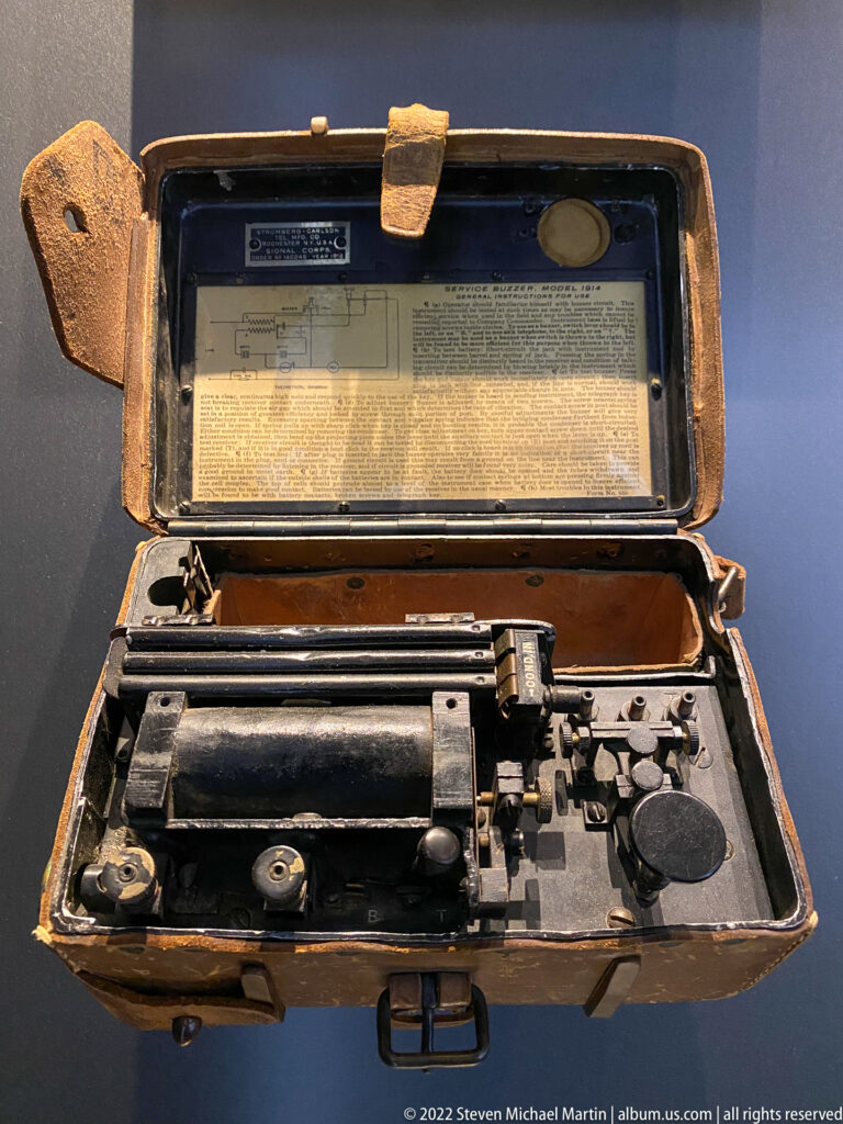 Historic black portable typewriter displayed open inside a worn brown fitted carrying case.