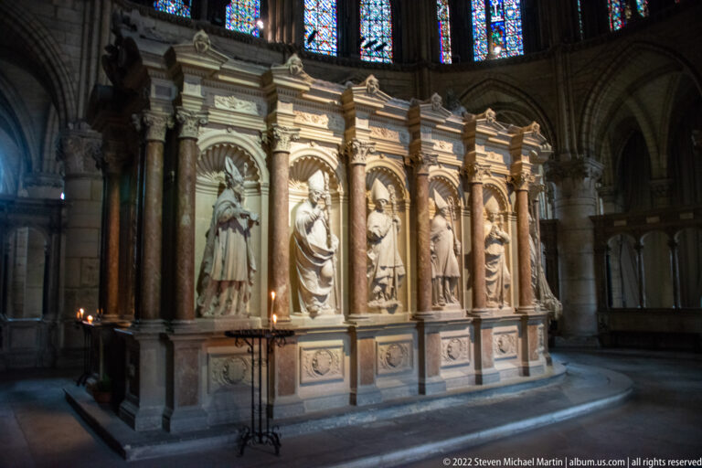 Large shrine with standing saint figures in arched niches between polished columns inside the basilica.