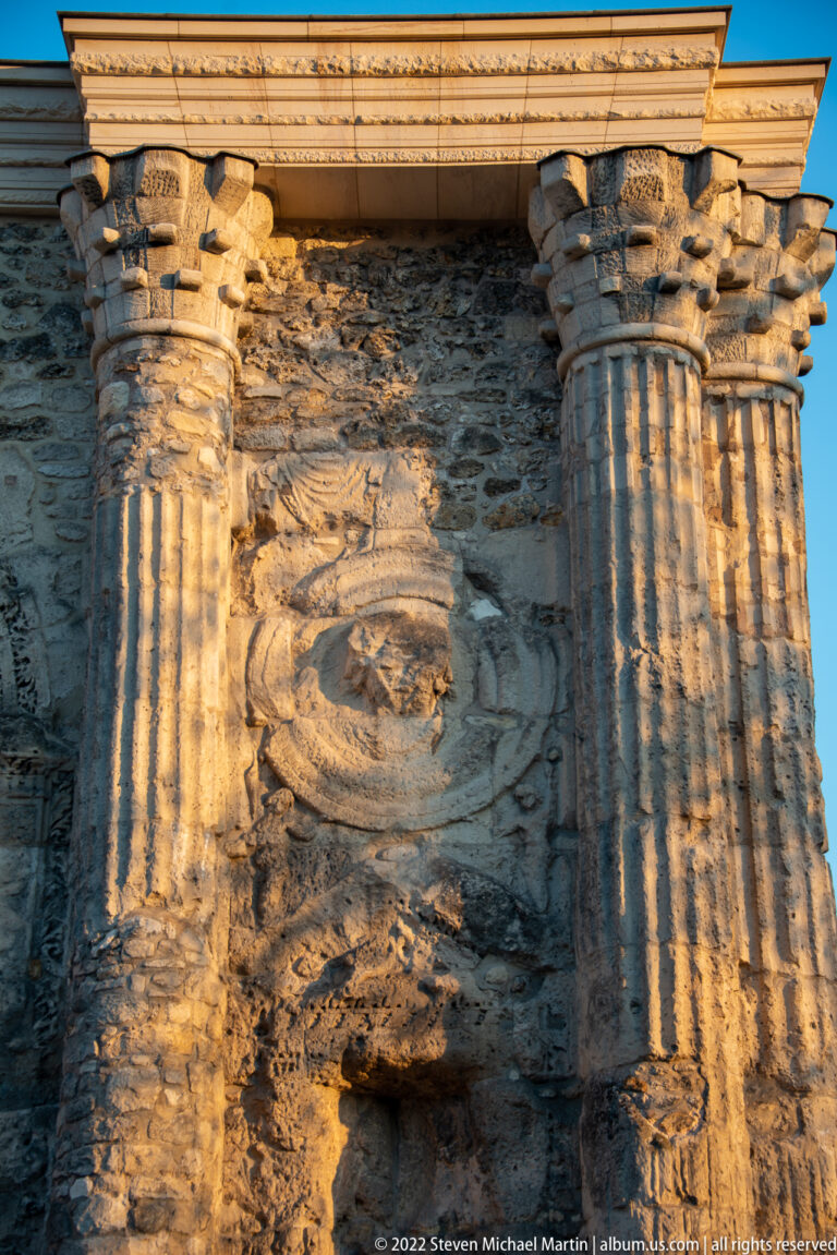 Weathered relief panel and fluted engaged columns on the Roman Porte de Mars in Reims.