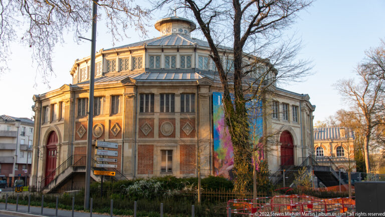 Art Deco Carnegie Library in Reims with brick walls, geometric stone decoration, tall windows, and polygonal central roof.