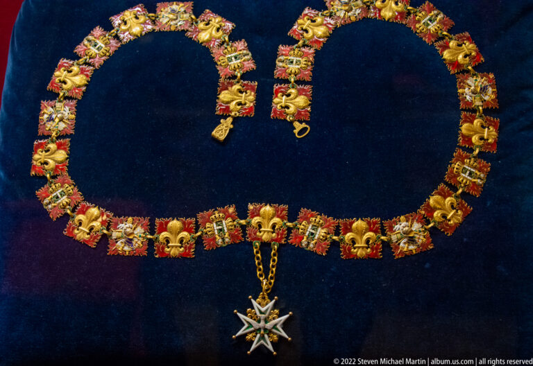 Ceremonial collar of gold fleur-de-lis and red enamel links with a large star-shaped pendant.