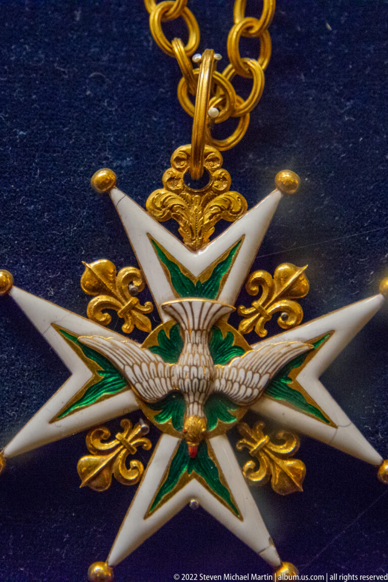 White eight-pointed enamel star with green inner points, gold ornament, and eagle suspended from a chain.