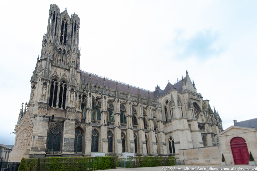 Side elevation of Reims Cathedral with flying buttresses, pinnacles, tall clerestory, and projecting Gothic chapels.
