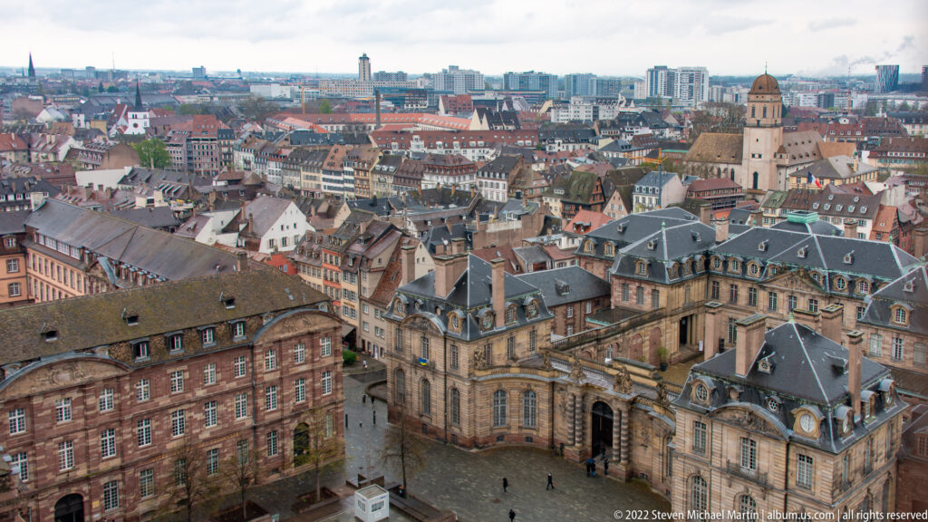 High view over Strasbourg rooftops, with the Palais Rohan and historic center extending toward modern districts.