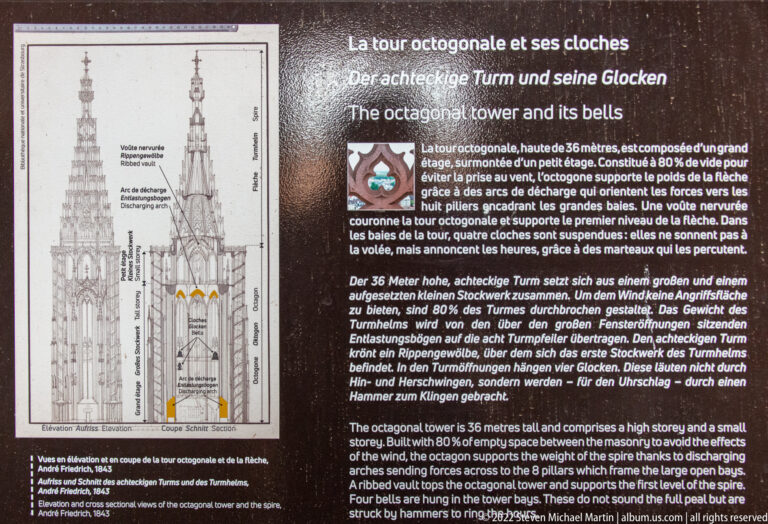 Trilingual interpretive panel with diagrams explaining Strasbourg Cathedral’s octagonal tower, bells, and spire structure.