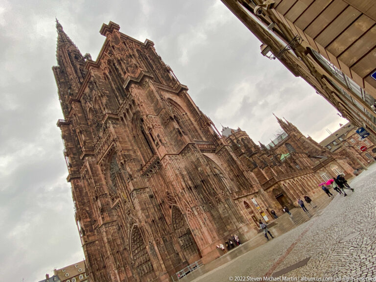 Tilted low-angle view of Strasbourg Cathedral's richly carved sandstone west façade and soaring tower.