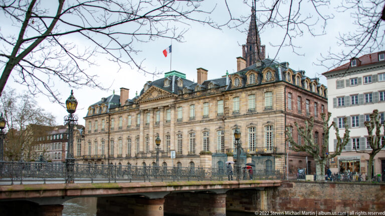 Palais Rohan beside the Ill, with its classical sandstone façade and Strasbourg Cathedral spire behind.