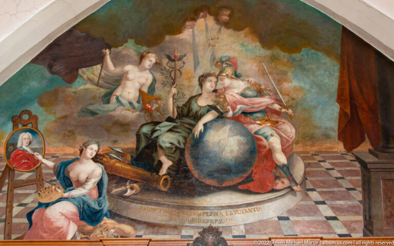 Allegorical painting with a seated woman beside a globe, surrounded by putti, attendants, and symbolic objects.