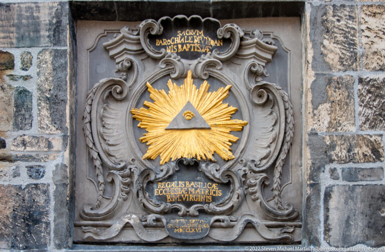 Baroque stone plaque with a gilded Eye of Providence in a radiant triangle and Latin inscriptions.