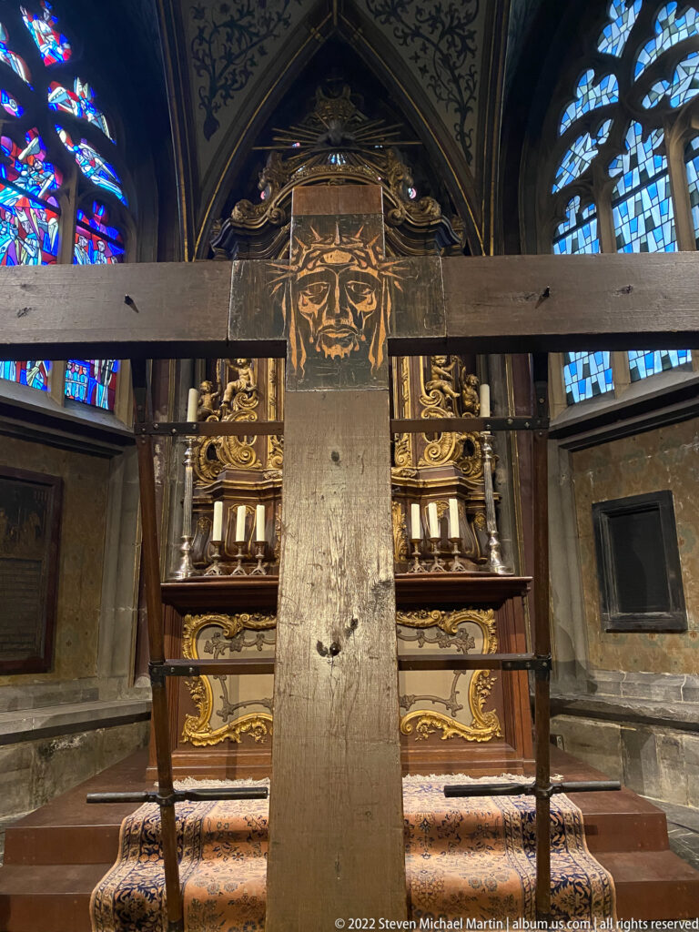 Simple slab-built Throne of Charlemagne on a raised platform behind a barrier inside Aachen Cathedral.