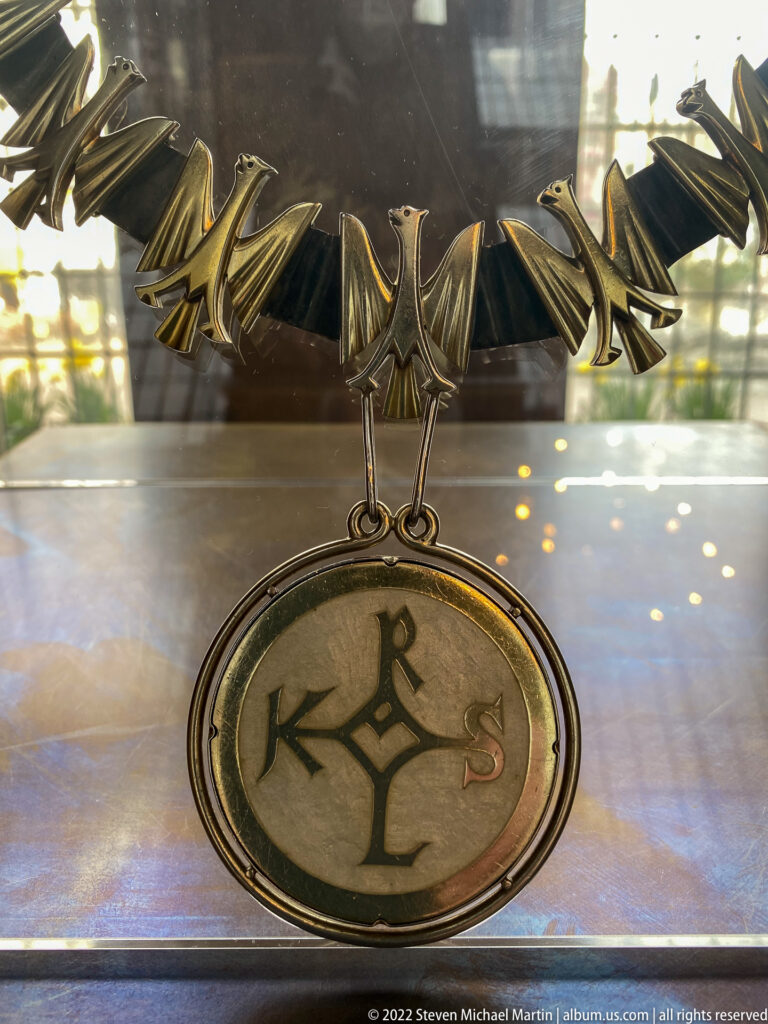 Metal eagle above a circular medallion bearing Charlemagne's interlaced monogram.