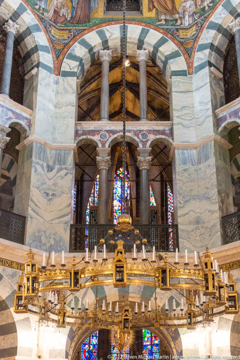 Wide interior view of the Barbarossa Chandelier beneath striped arches, marble surfaces, columns, and stained glass.