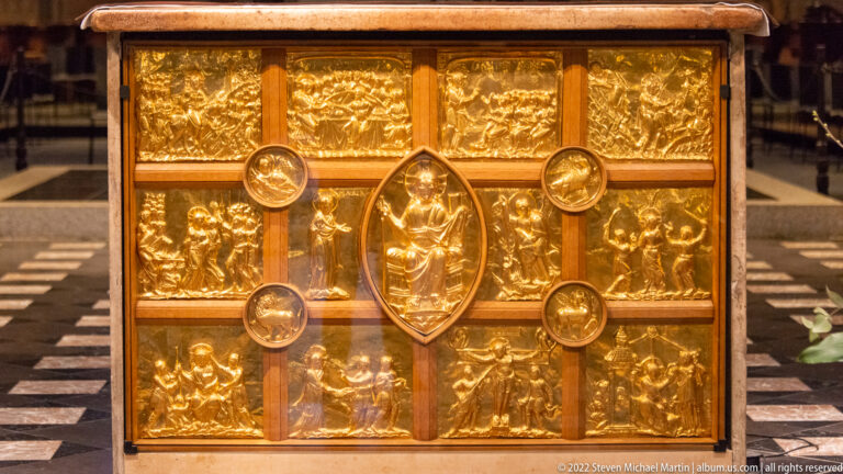Rectangular gilded chest or shrine with relief panels, central pointed medallion, and smaller roundels.