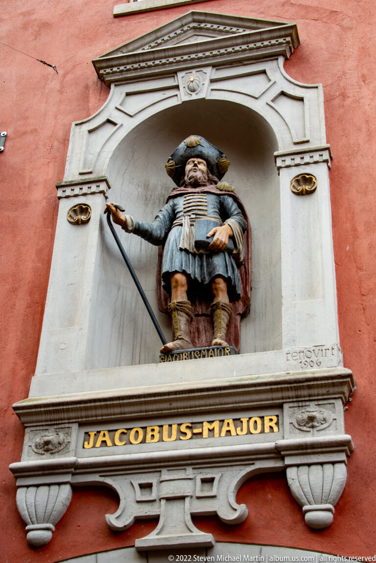 Polychrome statue of Saint James the Greater in a wall niche above the gilded inscription JACOBUS MAJOR.