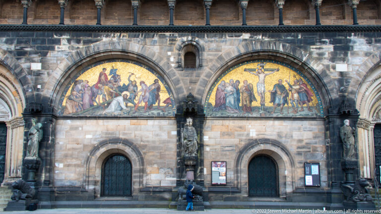 Two gold-ground biblical mosaics above adjacent arched doors on the west façade of Bremen Cathedral.