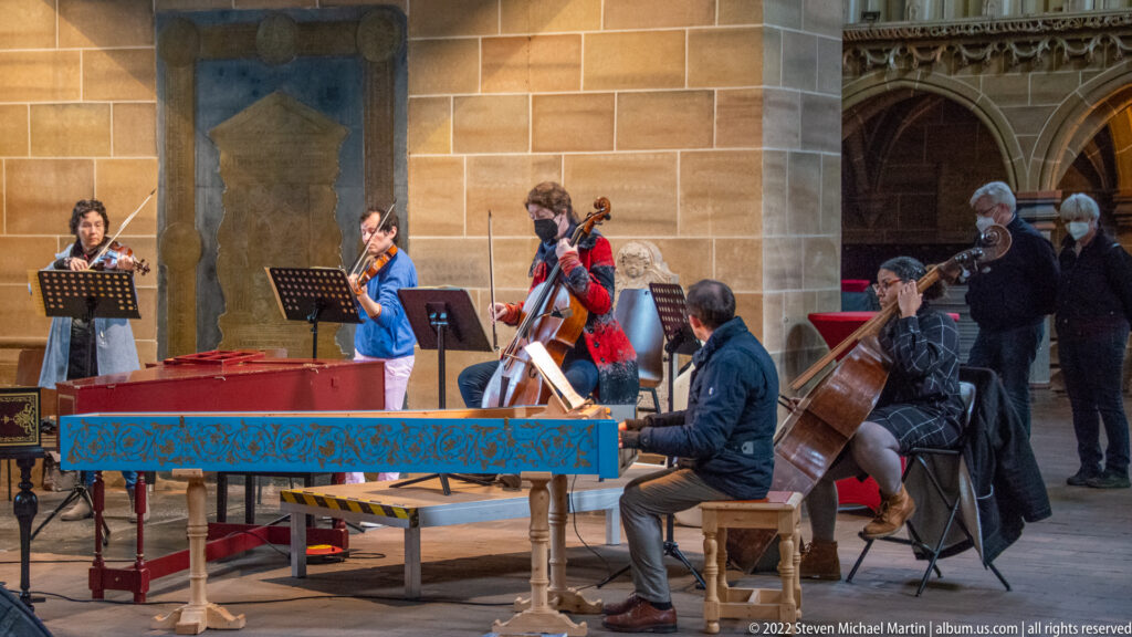 Small chamber ensemble performing with keyboard and string instruments inside Bremen Cathedral.