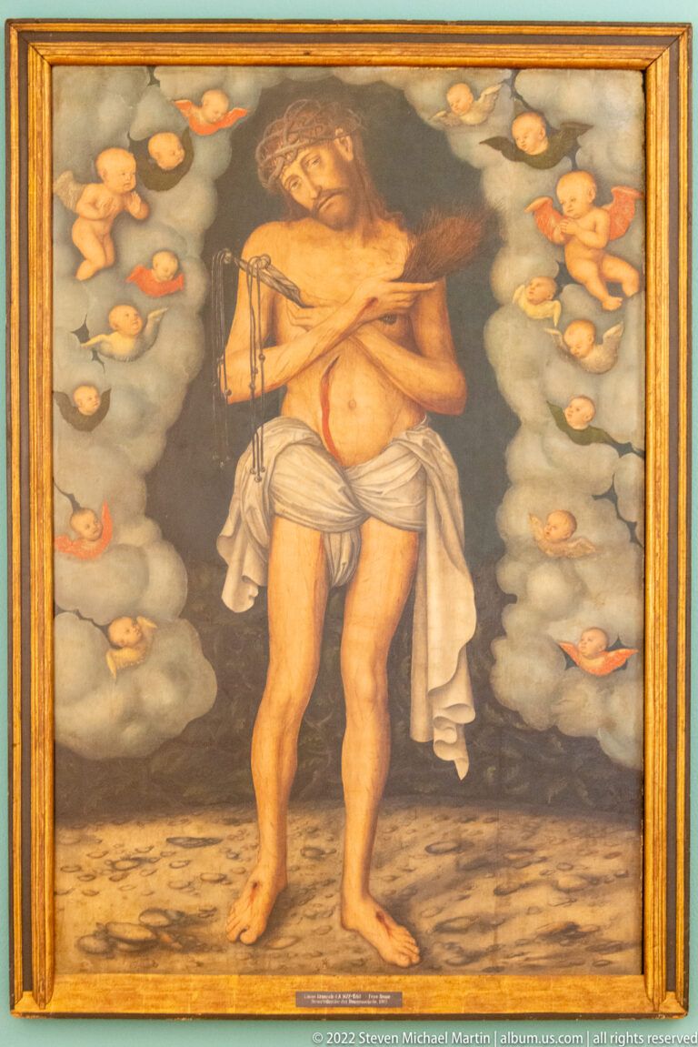 Devotional painting of Christ wearing a crown of thorns and loincloth, standing amid clouds.