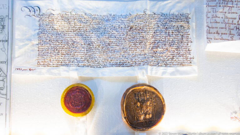 Historic handwritten parchment document with two pendant seals attached beneath the text.