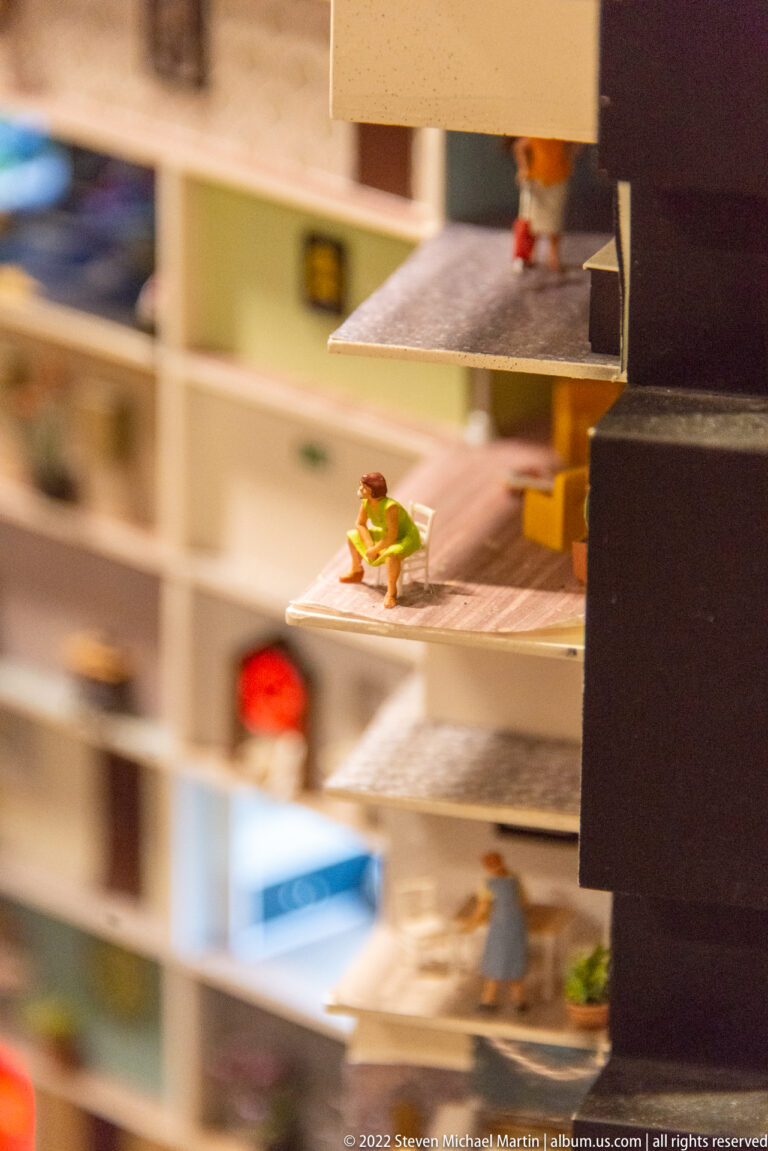 Single miniature figure stands on a narrow projecting ledge inside the exposed Elbphilharmonie model.
