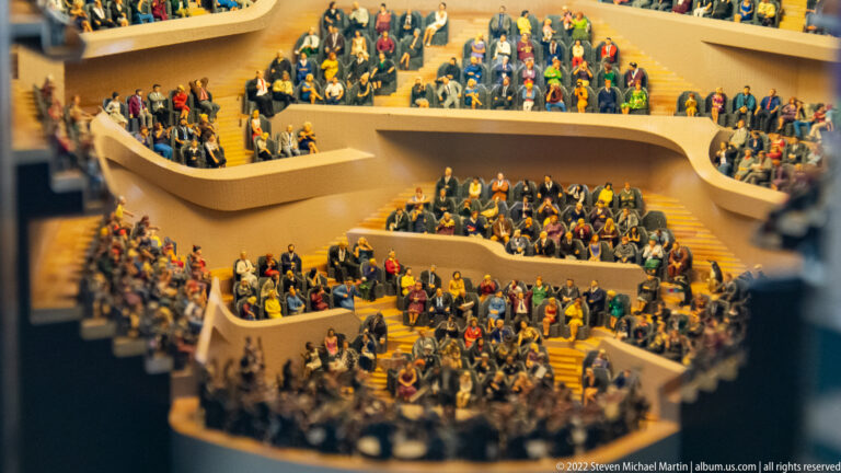 Close view of miniature spectators filling the curved terraced seating inside the Elbphilharmonie auditorium.