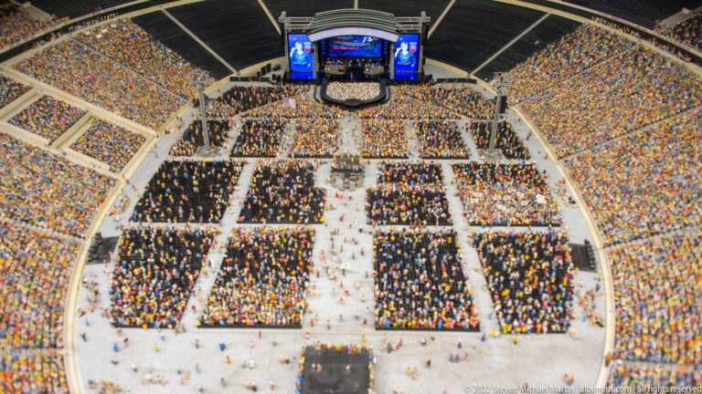 Miniature stadium packed for a concert, with stage, field-level crowd sections, and full spectator stands.