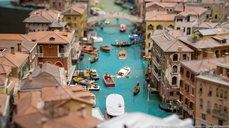 Miniature Venetian canal crowded with gondolas and small boats between closely packed buildings.