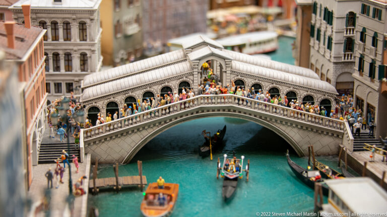 Miniature Rialto Bridge crowded with pedestrians above gondolas and boats on the Grand Canal.