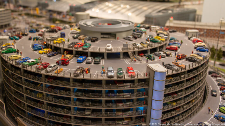 Round multistory model parking garage crowded with cars on open decks and rooftop spaces.