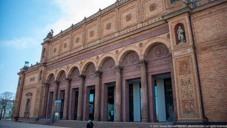 Historic Hamburger Kunsthalle façade with tall arched openings, columns, terracotta ornament, and sculpted figures in upper niches.