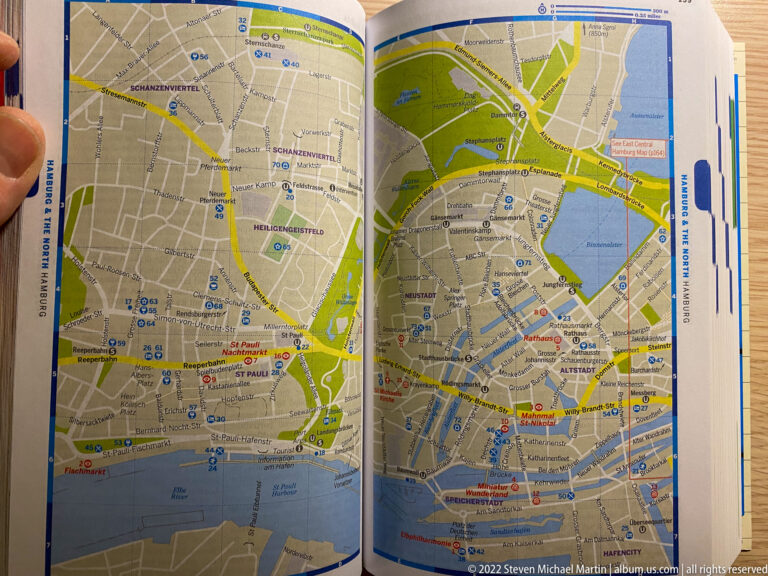 Open printed map of central Hamburg showing streets, parks, waterways, the Alster, and Elbe waterfront.