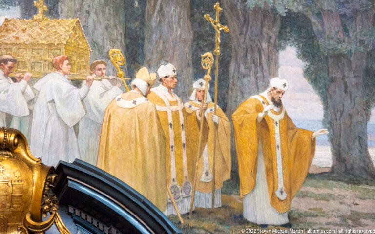 Detail of a historical mural showing bishops and clergy in gold vestments carrying croziers and a processional cross.